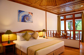 Cozy Bandos Maldives resort room with wooden decor & balcony