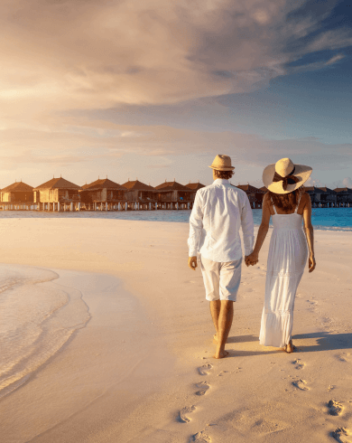 Couple strolling on Maldives beach at sunset