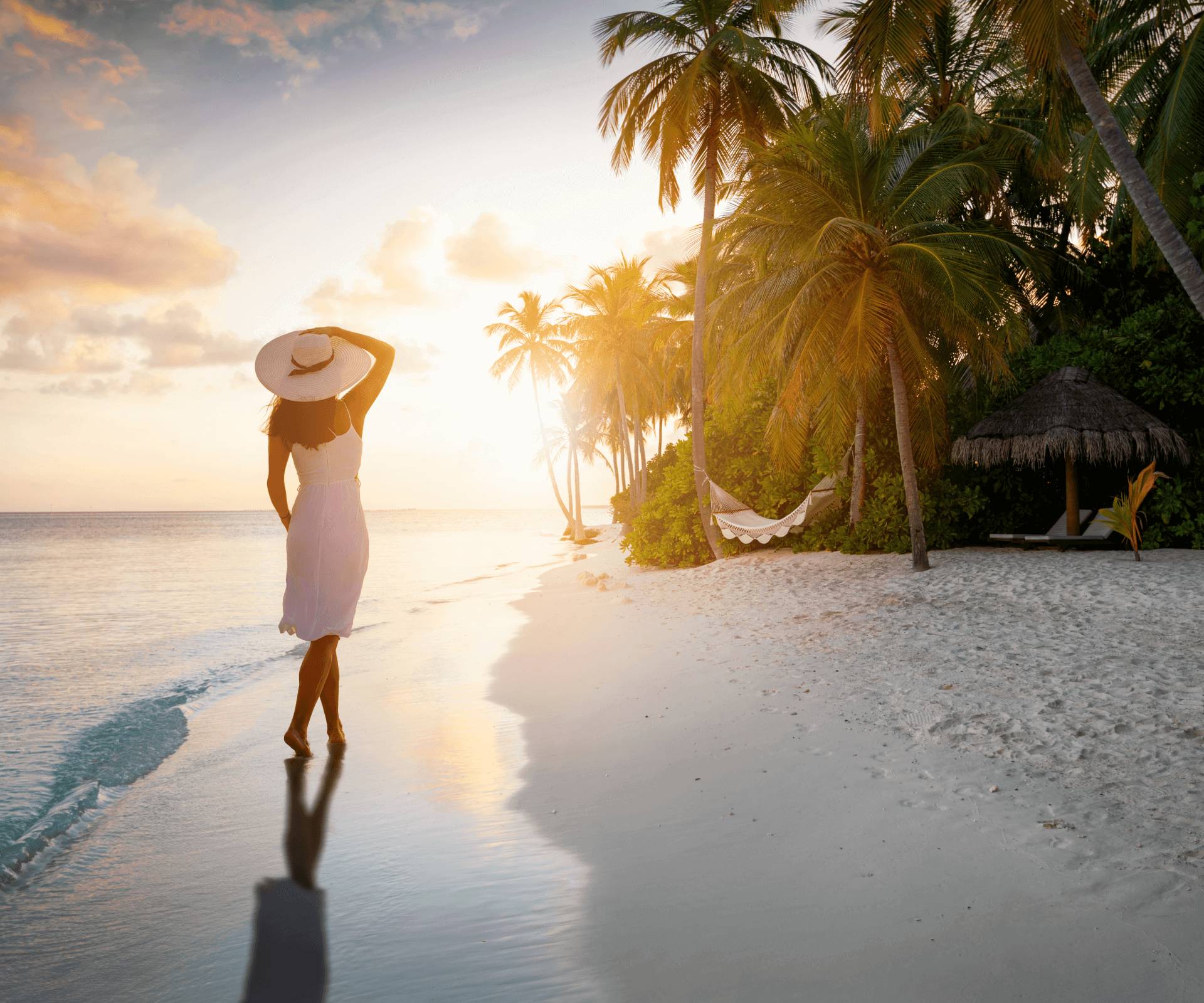 Woman walking on tropical beach at sunset