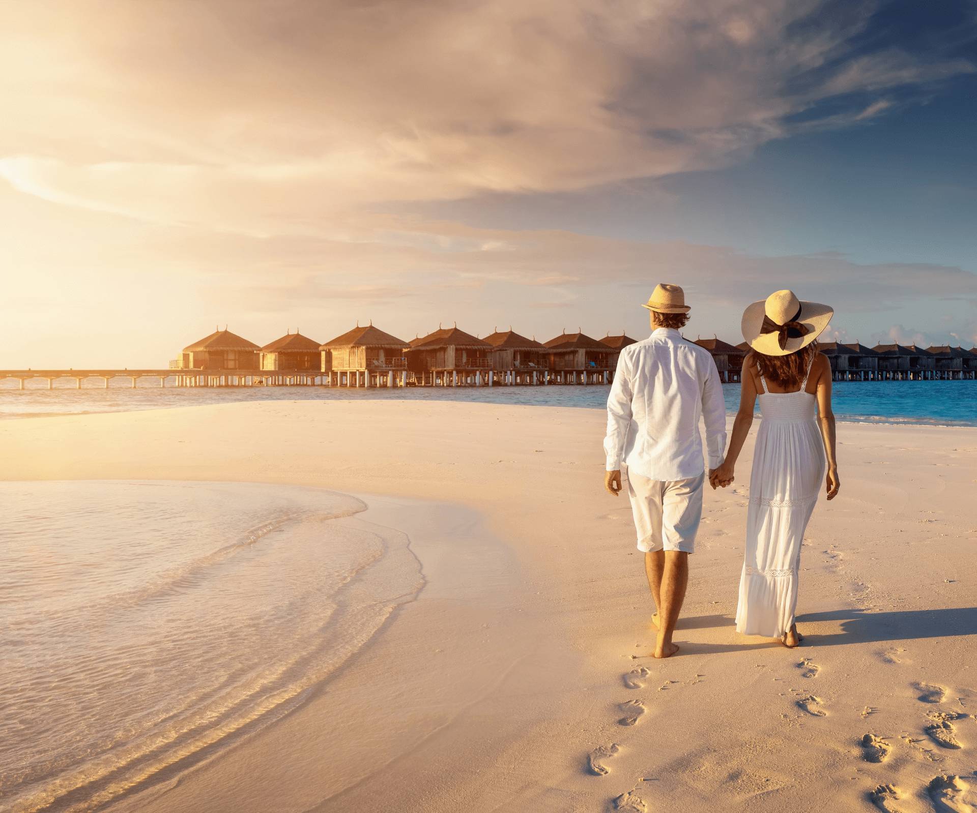 Couple strolling on Maldives beach at sunset